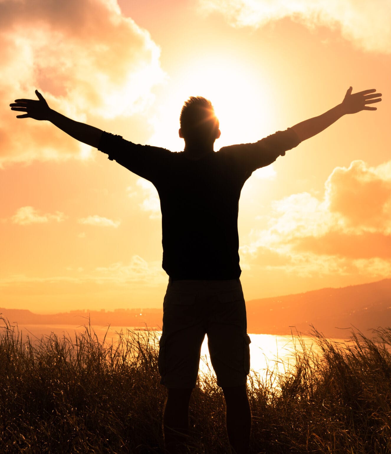 C'est une belle vie ! Un homme debout dans un champ au coucher du soleil ressentant de la liberté, de l'espoir et du bonheur